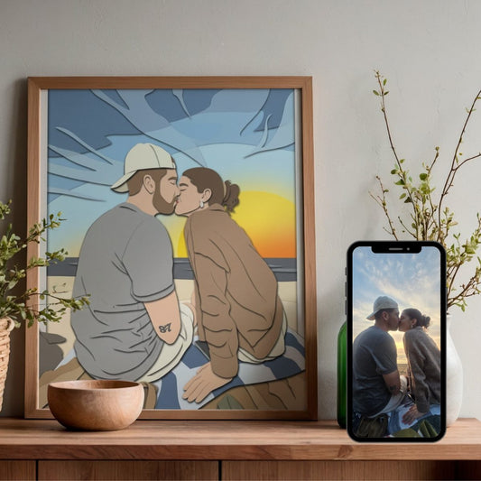 Affiche au style papier découpé d’un couple qui s’embrasse sur une plage au coucher du soleil, avec la photo d’origine affichée sur un téléphone